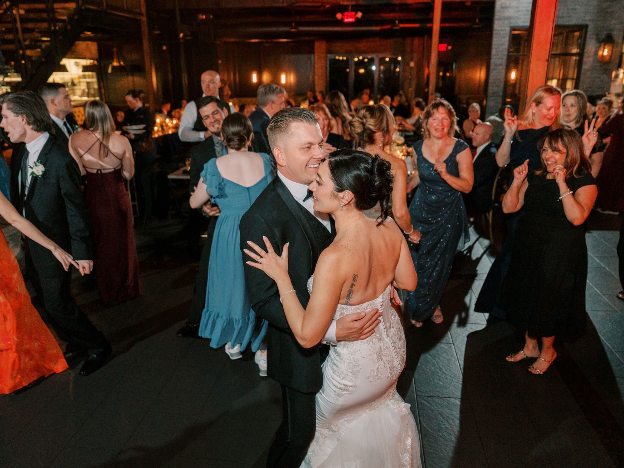 Bride and groom sharing a first dance surrounded by guests