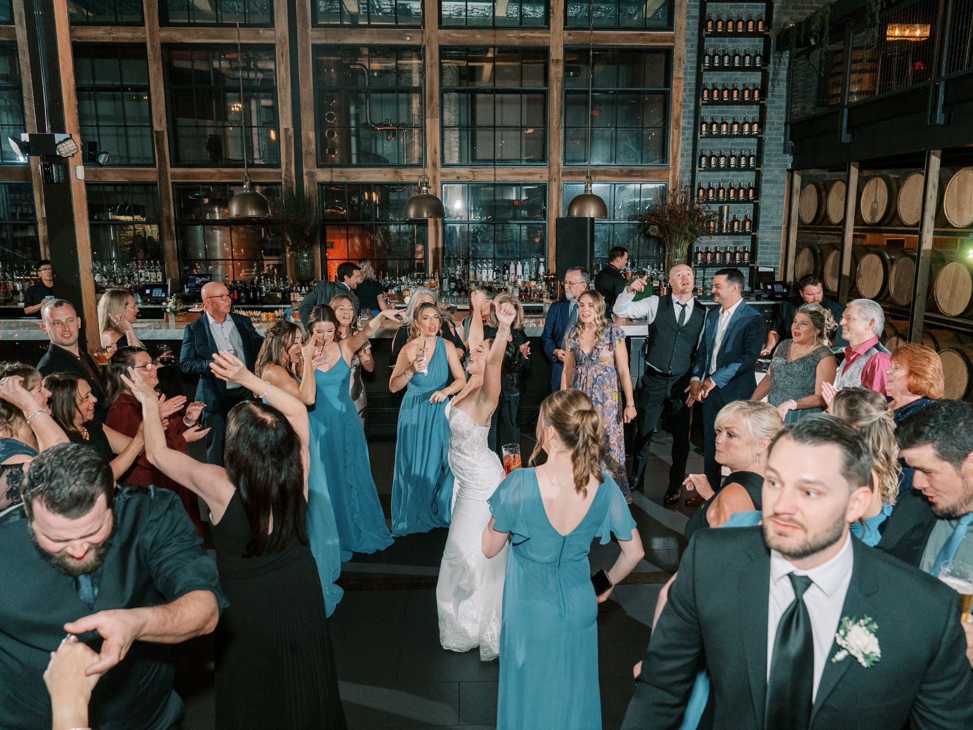 A packed Modern Era Weddings reception dance floor with guests celebrating under dramatic lighting