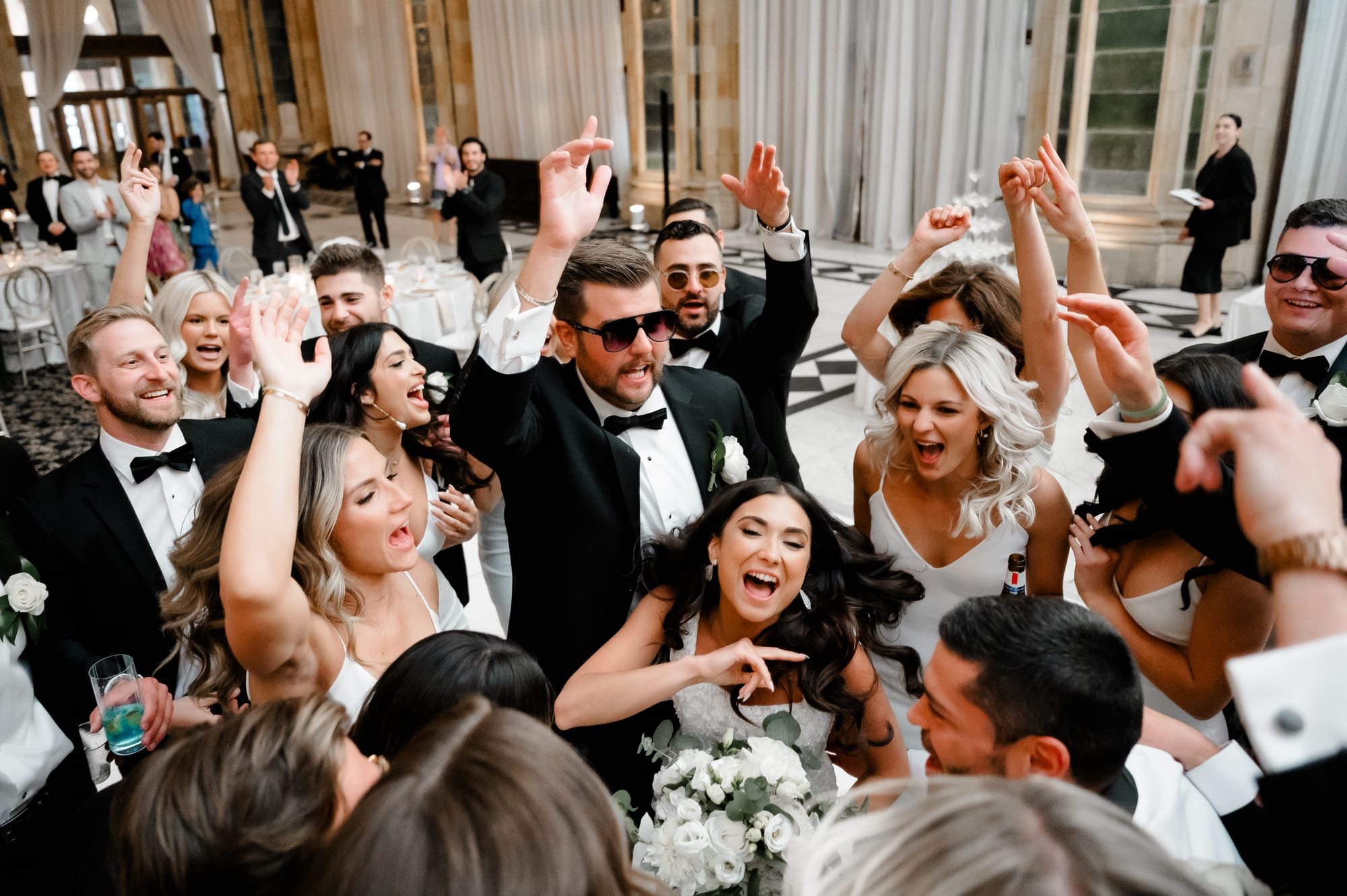 Crowd of guests celebrating around the bride and groom on the marble dance floor at The Pennsylvanian